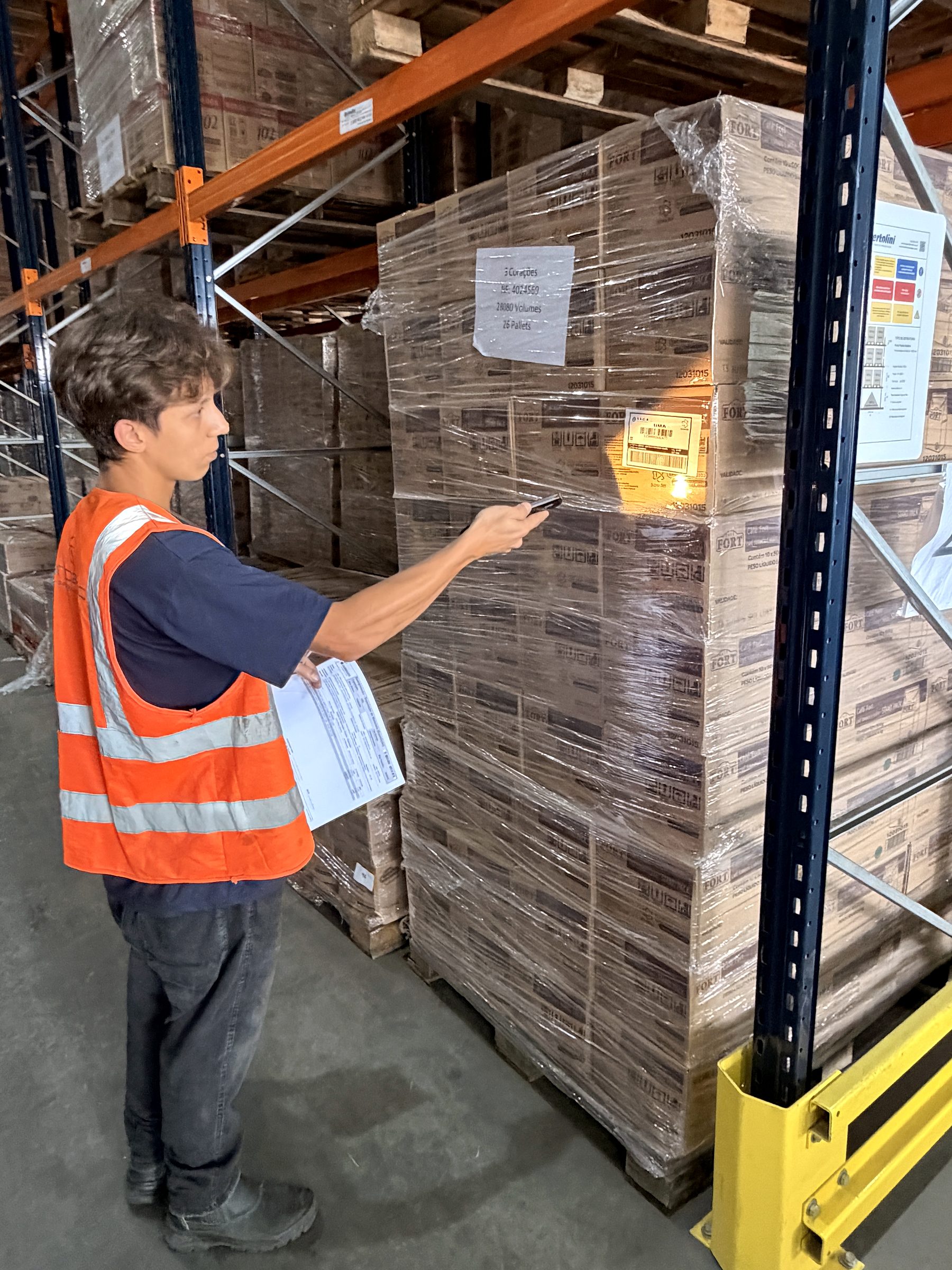 Operadora conferindo endereço de pallet com coletor no armazém de Guarulhos